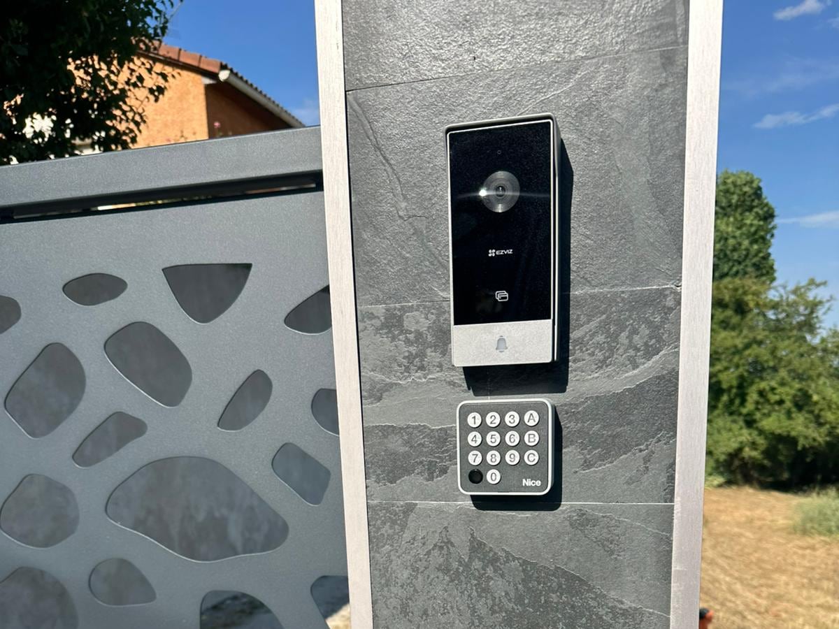 Platine d'interphone vidéo et clavier à code installés sur le pilier d'un portail